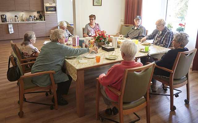 Bewoners van Kloek zitten aan tafel