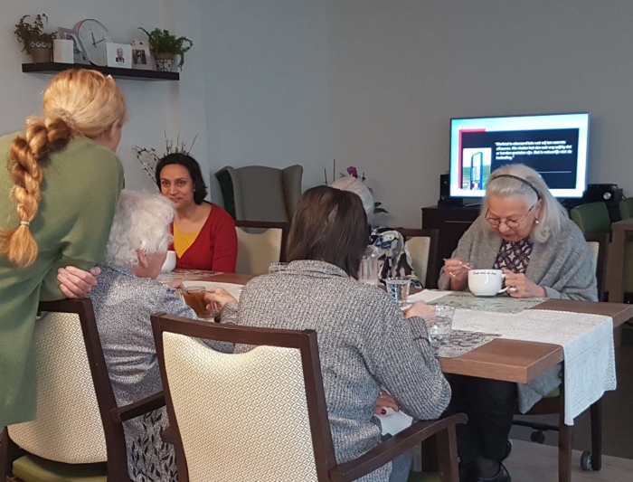 Sandra met bewoners in de woonkamer